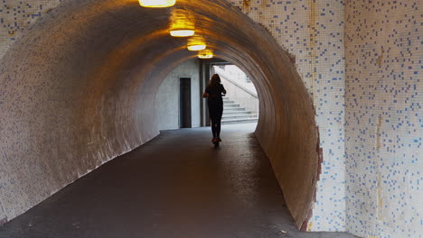 Girl-with-electric-scooter-drive-through-tunnel-underpass