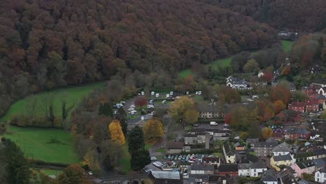 Aerial-view-of-Dulverton-market-town-in-Somerset,-dolly-push-into-the-Caravan-Club-touring-park-on-the-River-Barle