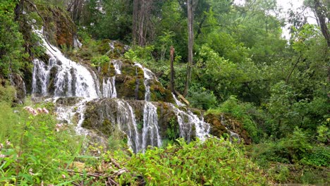 Several-tiers-of-cascading-water-surrounded-by-lush-green-bushes-and-trees-at-Krka-National-Park-in-Croatia