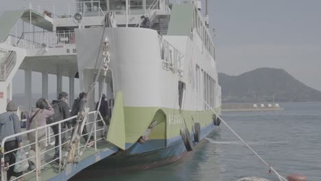 Japanese-people-boarding-ferry-from-Omishima-to-Hiroshima,-Inland-sea-of-Japan