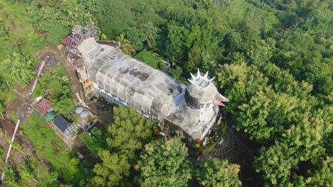 Aerial-tilt-up-view-of-Chicken-Church-to-reveal-evergreen-tropical-forest,-Java