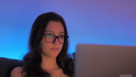 Young-Woman-Blogger-With-Glasses-Working-Late-at-Night-on-Laptop-Computer,-Close-Up-Slow-Motion