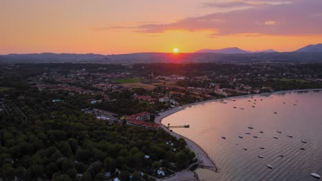 Aerial-viw-of-a-perfect-idyllic-sunset-above-Lago-di-Garda-and-Salo-city,-Italy