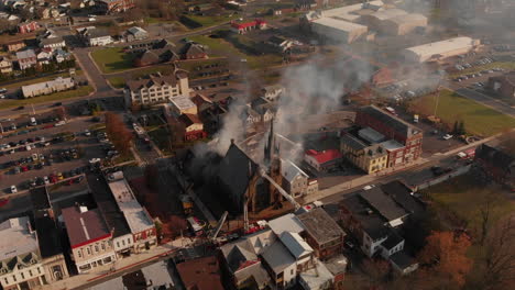 Fire-department-attempting-to-save-church-on-fire,-Aerial,-Slow-Motion