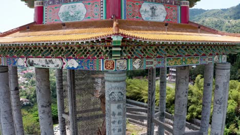Kuan-Yin-Goddess-of-Mercy-shrine-in-Kek-Lok-Si-Buddhist-temple-roof-architecture-details,-Aerial-drone-tilt-up-reveal-shot