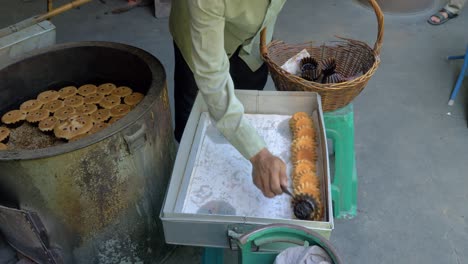 Die-Hand-Eines-Mannes-Nimmt-Traditionelle-Portugiesische-Thailändische-Kuchen-Aus-Dem-Ofen-Und-Legt-Sie-Auf-Ein-Tablett,-Zeitlupe
