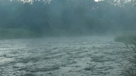 Relaxing-running-river-waters-with-steam-rising-across-the-treeline
