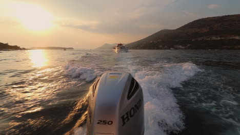Wunderschöne-Sonnenuntergangsaufnahme-Von-Einem-Laufenden-Boot-Und-Einer-Größeren-Yacht-Im-Hintergrund