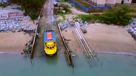 Aerial-shot-showing-amphibious-vehicle-driving-into-water-from-street,Malaysia