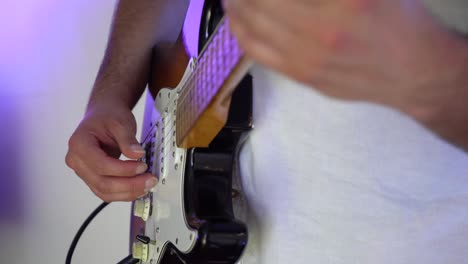 detail-shot-of-guitarist-playing-instrument