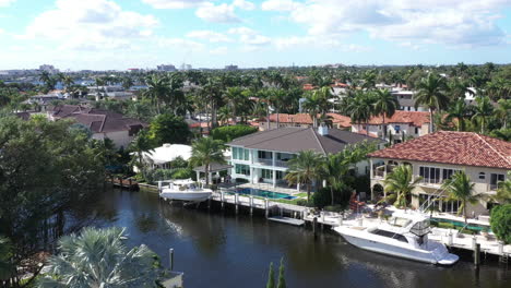 stylish-waterfront-mansions-and-sunny-moderate-tropical-weather,-aerial-dolly-out