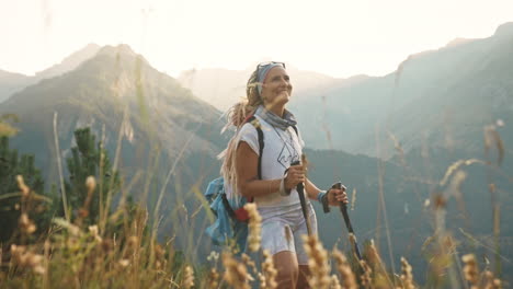 Blonde-woman-with-dreadlocks-hiking-at-sunset-smiles,-Benasque,-Spain,-medium-shot