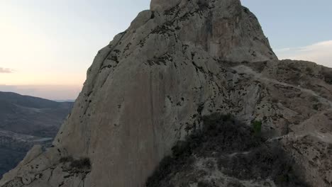 Flying-over-the-Pena-de-Bernal-monolith-at-sunset-in-Mexico--Aerial