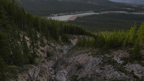 4k-drone-footage-of-diving-down-a-steep-rocky-slope-in-the-Canadian-Rocky-Mountains-between-vast-larch-forests