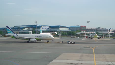 Pushback-Schlepper-Und-Flugzeug-Von-Air-Busan-Auf-Dem-Rollfeld-Des-Internationalen-Flughafens-Gimhae-In-Busan-An-Einem-Sonnigen-Tag