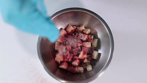Slow-motion-overhead-shot-of-chef-seasoning-potatoes