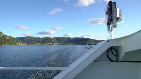 Passengers-view-from-Hydrogen-powered-ferry-Hydra---Walking-against-fence-and-looking-astern-with-Hjelmeland-in-background---Ferry-crossing-to-Nesvik-during-sunny-summer-day---Norway