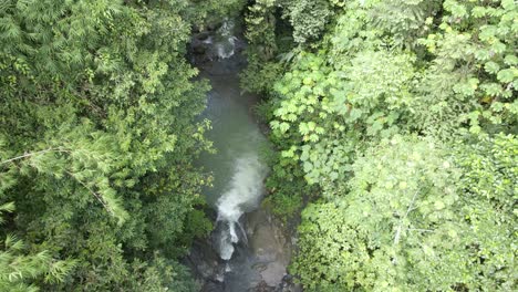 Top-down-aerial-shot-flying-over-a-waterfall-and-river-in-the-rainforest,-Costa-Rica