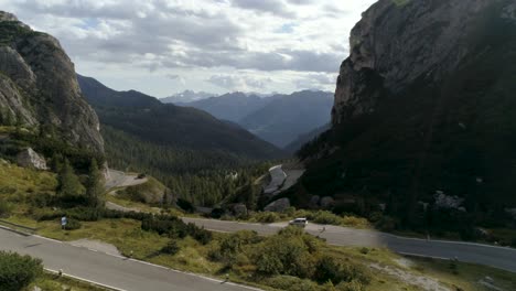 Aerial-in-the-Italian-Dolomites-with-a-Car-on-the-Side-of-the-Road-with-Mountains-in-the-Background