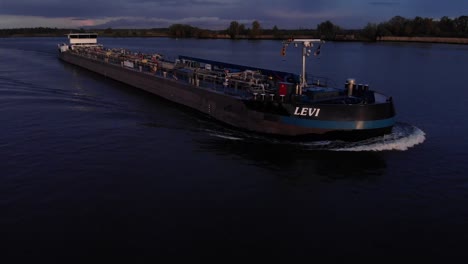 Levi-Tanker-Inland-Ship-Navigating-At-Sunset-In-Calm-River-In-Barendrecht-Near-Rotterdam,-South-Holland,-Netherlands