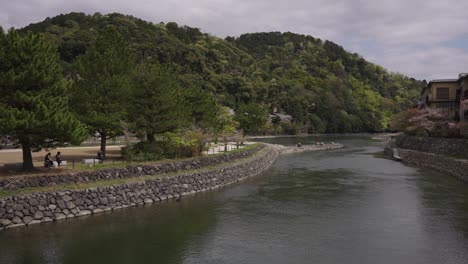 Peaceful-riverside-on-the-Ujigawa,-warm-day-in-small-Kyoto-town
