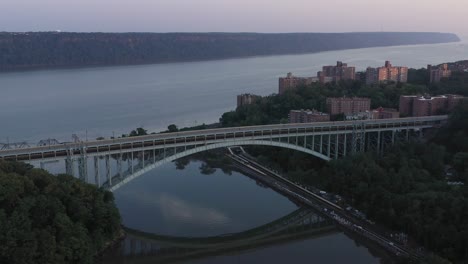 Wunderschöne-Luftumlaufbahn-Der-Henry-Hudson-Bridge-An-Der-Spitze-Von-Manhattan-In-New-York-City-Zur-Blauen-Stunde-Des-Sonnenaufgangs