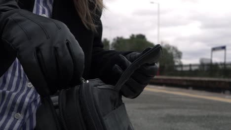 Business-woman-unzipping-briefcase-on-train-platform