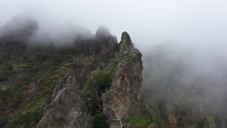 Drohnenaufnahme-Des-Nonnentals-Auf-Madeira,-Das-Sich-Mit-Dünnen-Und-Düsteren-Wolken-über-Den-Steilen-Rand-Des-Berghangs-Bewegt