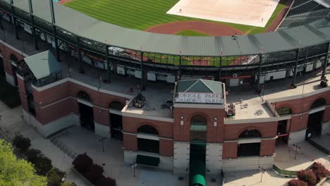 Oriole-Park-at-Camden-Yards,-home-stadium-field-for-Baltimore-Orioles,-Major-League-Baseball-MLB-professional-team,-aerial-entrance-tilt-up,-field-covered