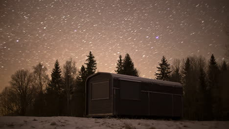Black-Thermowood-Cabin-Near-Coniferous-Forest-At-Night-With-Stars-In-The-Sky