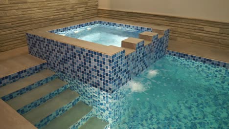 Indoor-Jacuzzi-With-Water-Flowing-Into-Swimming-Pool