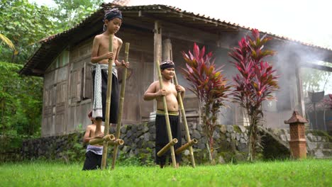 Los-Niños-Juegan-Con-Zancos-De-Bambú-En-El-Patio-De-La-Casa