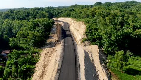 New-built-asphalt-road-in-Indonesia-jungle-area,-aerial-view