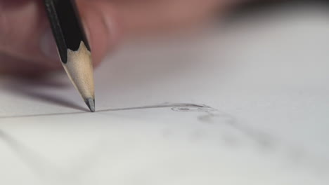 Closeup-of-a-hand-holding-a-black-pencil-drawing-a-line-in-a-picture