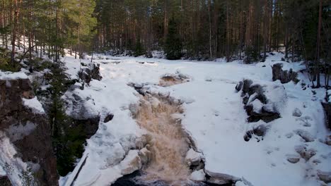 Vista-Aérea-De-Una-Cascada-En-Un-Bosque-Sueco-Durante-El-Invierno