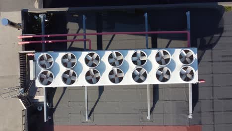 Industrial-AC-system-with-14-fans-on-rooftop-at-sunny-day---Top-down-ascending-aerial-from-closeup-to-overview