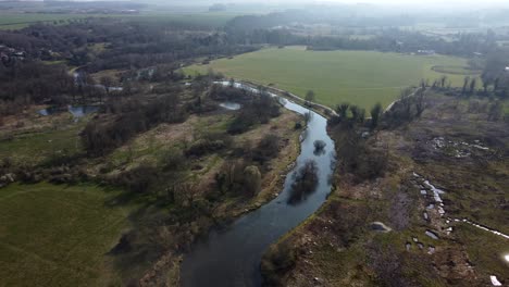 Top-down-aerial-view-of-river-and-wetland-in-countryside-of-England