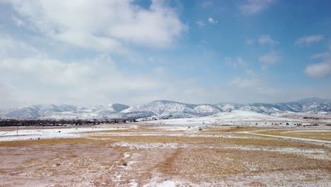 Tagsüber-über-Verschneite-Felder-In-Richtung-Der-Ausläufer-Der-Colorado-Rockies-Fliegen,-Aus-Der-Luft