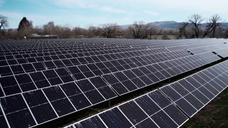 Langsam-über-Horizontale-Reihen-Von-Solarpaneelen-Auf-Einem-Bauernhof-Für-Grüne-Energie-Fahren,-Luftwagen