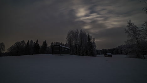 video-of-wooden-holiday-houses-covered-in-snow-in-the-rural-countryside-with-the-clouds-passing-by-in-timelapse