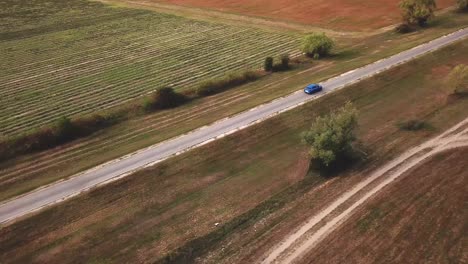 Aerial-view-of-a-blue-Ford-Puma-speeding-on-a-country-road