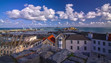 Evening-timelapse-view-over-a-small-town-beside-the-port-in-Guernsey-island-in-the-English-Channel-off-the-coast-of-Normandy,-part-of-the-Bailiwick-of-Guernsey