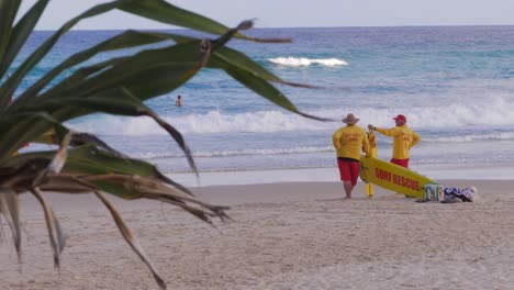 Lifeguards-On-Duty-Standing-At-Beach-Watching-Surfers---South-Gorge-Beach-In-Summer-At-Point-Lookout,-North-Stradbroke-Island,-Australia