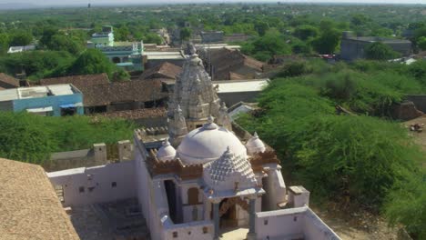 Aerial-View-Of-Nagarparkar-Bazaar-Temple-With-Birds-Flying-From-Tower