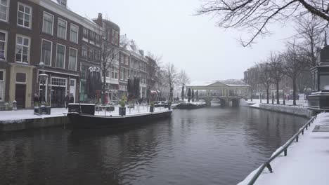Leiden-and-Rhine-river-in-winter-snow,-Koornbrug-Bridge-background,-Netherlands