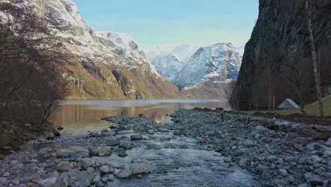 Überqueren-Sie-Den-Undredal-Fluss,-Bevor-Sie-Bei-Wintersonnenaufgang-über-Den-Aurlandsfjord-Fliegen---Norwegen-Luftaufnahme