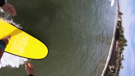 Vertical-video,-POV-GoPro-of-person-surfing-on-wave-on-foamboard,-then-falling