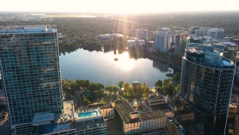 4K-Aerial-drone-clip-panning-through-buildings-to-reveal-Lake-Eola-Park-in-downtown-Orlando,-Florida