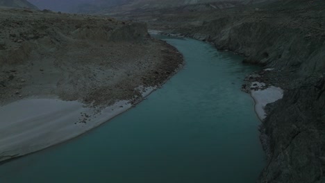 Luftaufnahme-über-Türkisfarbenem-Flusswasser-Im-Hunza-Tal-An-Einem-Dunklen,-Launischen,-Bewölkten-Tag
