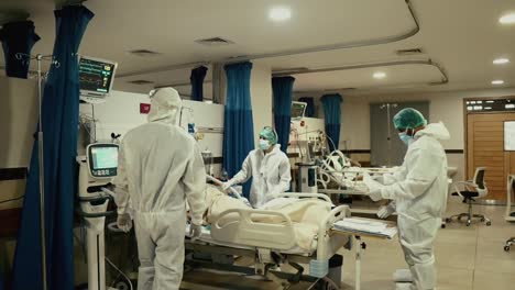 Equipo-De-Médicos-Que-Atienden-Al-Paciente-Covid-19-Acostado-En-Una-Cama-De-Hospital